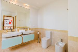 Un baño con dos lavabos, un inodoro y un espejo. en Villa La Terrasse Palheiro Village with private pool by HR Madeira, en São Gonçalo 31 fotos más