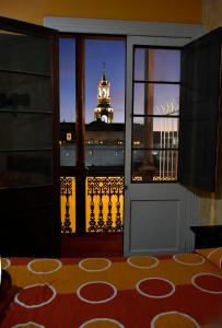 a room with a view of a clock tower from a window at Hostal Los Balcones de Moral y Santa Catalina in Arequipa