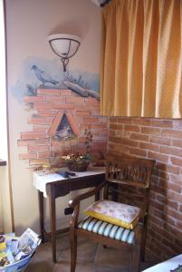 een kamer met een bureau en een stoel naast een bakstenen muur bij Agriturismo La Cascina in Bossolasco