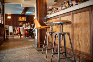 a row of stools at a bar in a restaurant at The Angel Inn Hotel in Pershore