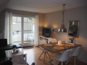 een woonkamer met een tafel en een televisie bij Strandmuschel in Zingst