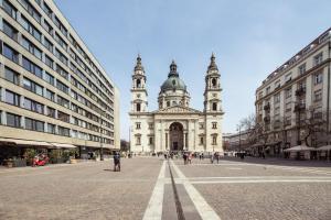a large white building with two towers on a street at BudapestEasyFlat Basilica Lux in Budapest