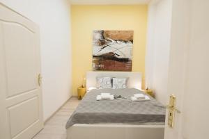 a bedroom with a bed and a painting on the wall at BudapestEasyFlat Basilica Lux in Budapest