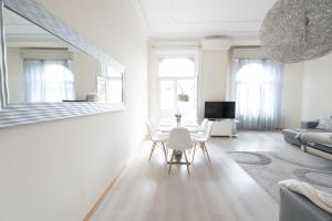 ein weißes Wohnzimmer mit einem Tisch und Stühlen in der Unterkunft BudapestEasyFlat Basilica Lux in Budapest