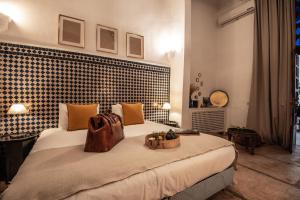 a bedroom with a large bed with a purse on it at Riad Palais Calipau in Marrakesh