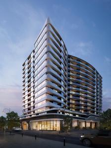 a tall building with a car parked in front of it at Domi Serviced Apartments in Glen Waverley