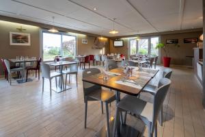 une salle à manger avec des tables et des chaises dans un restaurant dans l'établissement Campanile Lorient - Lanester, à Lanester