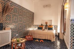 a bedroom with a bed and a tiled wall at Riad Palais Calipau in Marrakesh