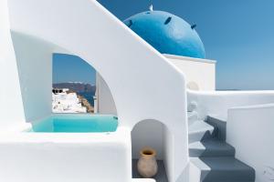 a white toilet sitting next to a blue wall at Oia Spirit Boutique Residences in Oia