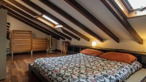 - une chambre avec un lit dans un dortoir doté de parquet dans l'établissement The attic of Milan with terrace city view, à Milan