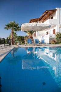 - une piscine avec des chaises et un parasol dans l'établissement Villa Michalis, à Istron