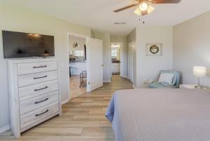a bedroom with a bed and a dresser with a tv at La Casa Del Mar 602 Star5Vacations in Dunedin