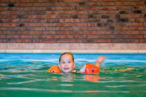 a baby in a pool in a swimming pool at Hotel Hofker in Nes