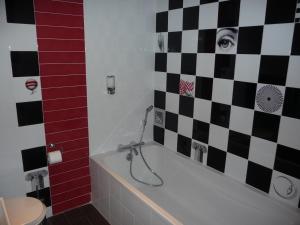 a bathroom with a black and white checkered wall at Hôtel Spunta Di Mare in Ajaccio
