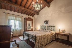 a bedroom with a bed and a chandelier at Castello di Volpaia in Radda in Chianti +100 photos