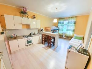 małą kuchnię z białymi szafkami i jadalnią w obiekcie KK Apartments w Pradze