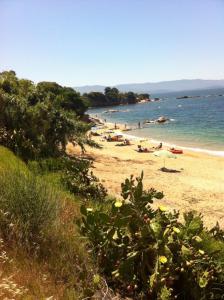 a beach with people laying on the sand and the water at Hôtel Spunta Di Mare in Ajaccio