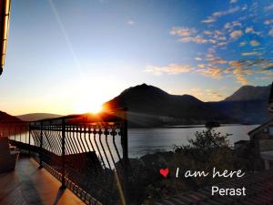 a view of a lake from a balcony with the sunset at Apartment Mediterraneo Blue Sky in Perast
