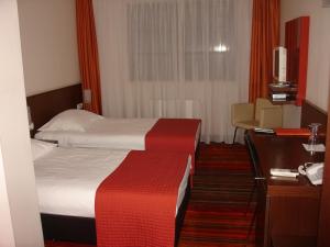 ein Hotelzimmer mit einem Bett und einem Schreibtisch in der Unterkunft B&B Janežič in Ljubljana