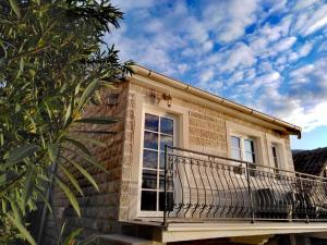 a brick house with a balcony on the side at Apartment Mediterraneo Blue Sky in Perast