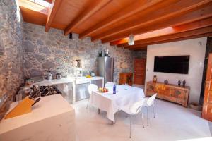 a kitchen with a table with chairs and a stove at La Molina NK in Tindaya