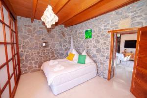 a bedroom with a bed in a stone wall at La Molina NK in Tindaya