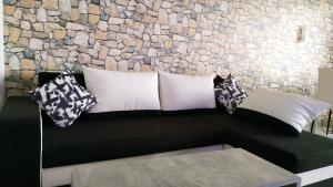un divano nero con cuscini contro un muro di pietra di Your2ndhome-3 a Sindelfingen