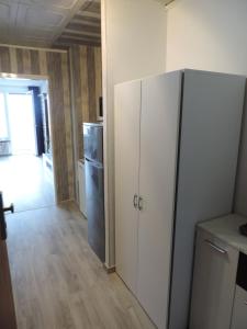 una cucina con un grande frigorifero bianco e un corridoio di Your2ndhome-3 a Sindelfingen Altre 5 foto