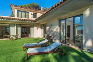 a garden with two lounge chairs on the grass at Nou Sol Solet in Begur