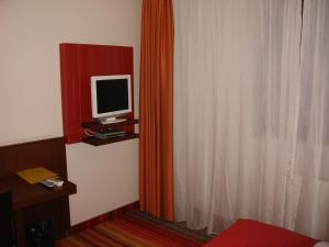 Habitación con TV en un estante y cortina en B&B Janežič en Liubliana