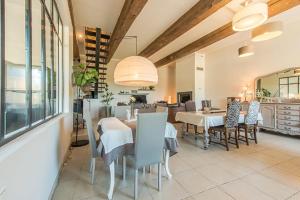 a dining room with a table and chairs and a kitchen at Au Paradis Cathare in Fraissé-des-Corbières