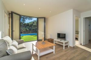 a living room with a couch and a tv and a table at Nou Sol Solet in Begur