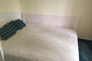 Una cama blanca con dos almohadas encima. en Balaton Charm Cottage, Your House in Balatonfüred, en Balatonfüred