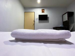 - un lit avec une couverture blanche dans l'établissement SMART HOTEL SEKSYEN 15 SHAH ALAM, à Shah Alam