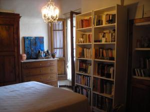 ein Schlafzimmer mit einem Bett und einem Bücherregal mit Büchern in der Unterkunft La Casa Di Dina in Castelmuzio