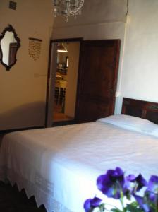 ein Schlafzimmer mit einem Bett mit lila Blumen darauf in der Unterkunft La Casa Di Dina in Castelmuzio