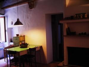 a kitchen with a table with chairs and a television at La Casa Di Dina in Castelmuzio