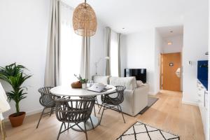 sala de estar con mesa y sillas en Aspasios Verdi Apartments, en Barcelona