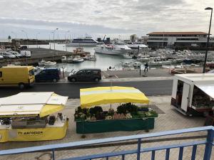 un mercado con una sombrilla amarilla y barcos en un puerto deportivo en Escale avec vue mer sur les quais de l’Ile d’Yeu, en Île d'Yeu