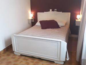 a white bed in a room with two lamps at Un petit coin de campagne dans le pays de Saint-Gilles in Saint-Maixent-sur-Vie +5 photos