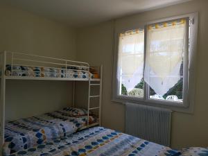 a bedroom with two bunk beds and a window at Maison pour 6 au coeur de Saint-Hilaire-de-Riez in Saint-Hilaire-de-Riez