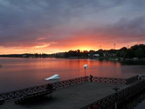a dock on a lake with a sunset in the background at Dom Brama Mazur in Ostróda
