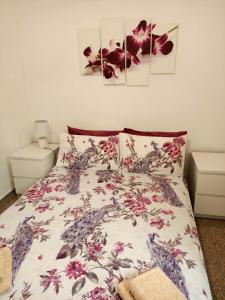 a bedroom with a bed with a floral bedspread at LA MAGIA DE PLAYA in Puerto de Sagunto