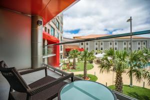 a balcony with a table and chairs and palm trees at Choctaw Casino Hotel - Grant in Grant