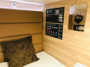 a headboard of a bed with a mirror and a pillow at Sauna & Capsule AMZA (mens only) in Osaka