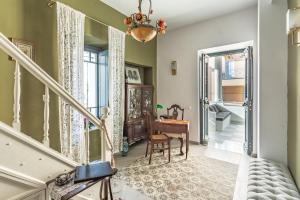 a hallway with a staircase with a table and a piano at CAMARA SUITES in Andros