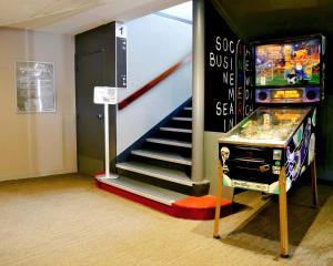 a room with a pinball machine and a staircase at ibis Laval Le Relais D'Armor in Laval