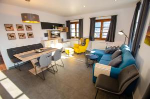 a living room with a blue couch and a table at Post Residence Apartments by All in One Apartments in Zell am See