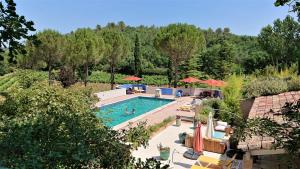 una piscina al aire libre con sillas y sombrillas en Une Campagne En Provence, en Bras