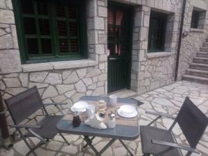 stół i krzesła na patio z budynkiem w obiekcie House On The Mountain w mieście Eptalofos
